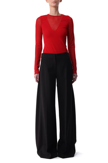 Model wearing a red long sleeve top with sheer V-neck detail