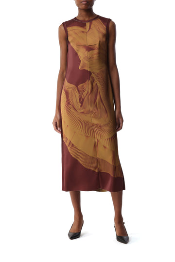 Model wears the Dancing Pleat Satin Sheath Dress, featuring a sleeveless silhouette, clean architectural lines, and an abstract, fluid pattern. view 1