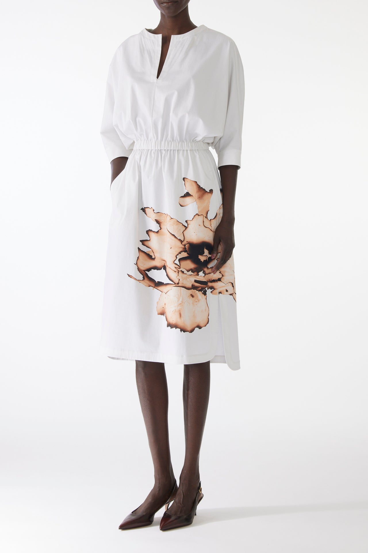 Model wearing cotton dress with dolman sleeves and an allover floral print, featuring a relaxed fit and softly structured silhouette. view 1