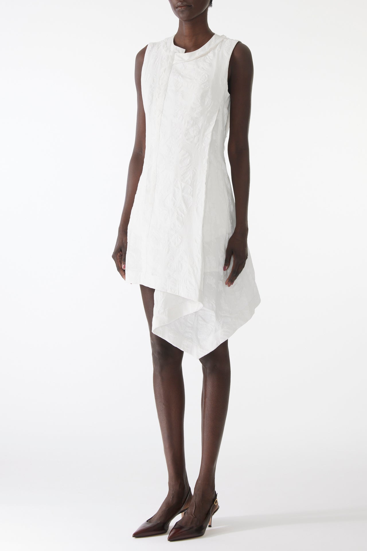 Model wearing mini dress in textured cotton with burnt dot print, featuring a clean neckline and asymmetrical hem. view 2