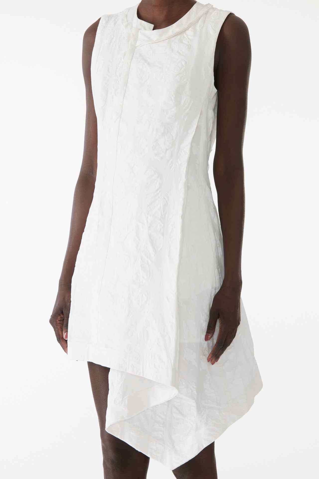 Model wearing mini dress in textured cotton with burnt dot print, featuring a clean neckline and asymmetrical hem. view 4