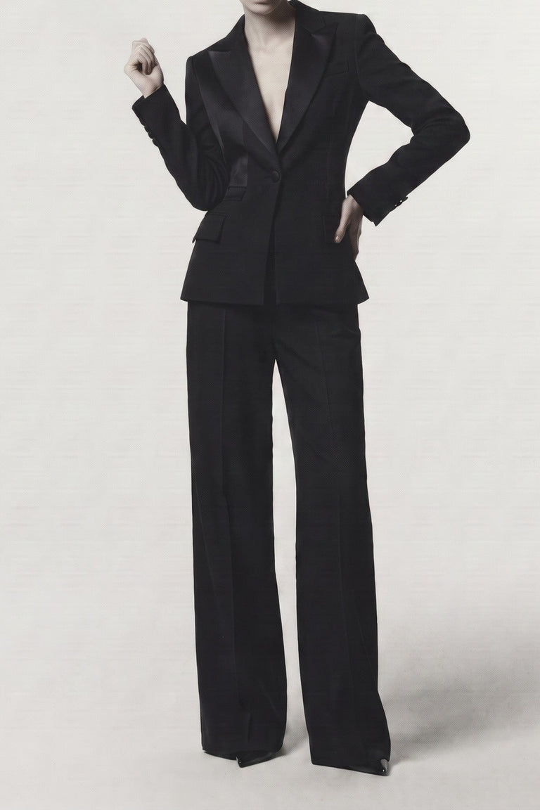 A model wearing a navy tailored pantsuit with a structured blazer and wide-leg trousers, photographed against a plain light gray studio background. view 1