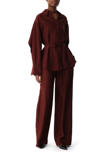Model wearing a deep garnet crinkled jacquard shirt with a belted waist view 1