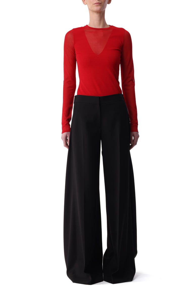 Model wearing a red long sleeve top with sheer V-neck detail  view 1