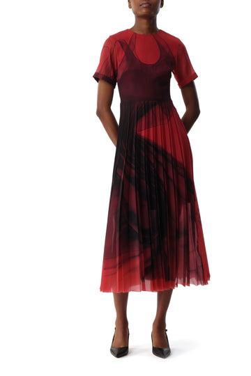 Model wearing a red and black pleated chiffon midi dress by Jason Wu. The dress features short sleeves, a fitted bodice, and a flowing skirt with an abstract Dancing Pleat print that creates a sense of movement. view 1