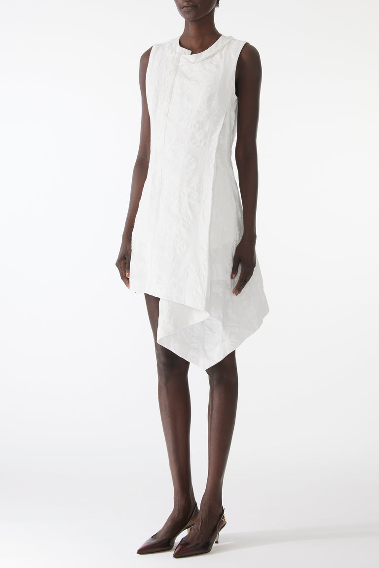 Model wearing mini dress in textured cotton with burnt dot print, featuring a clean neckline and asymmetrical hem. view 2