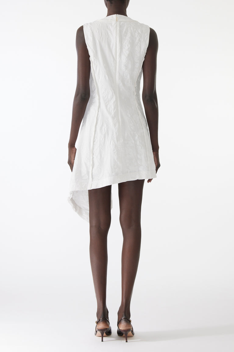 Model wearing mini dress in textured cotton with burnt dot print, featuring a clean neckline and asymmetrical hem. view 3