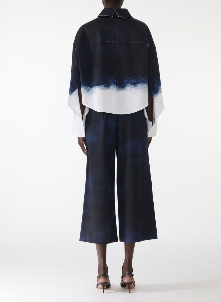 Model wearing wide-leg stretch cotton pants with elastic waistband and navy-and-white smudged print, styled with matching pop-over shirt. view 3