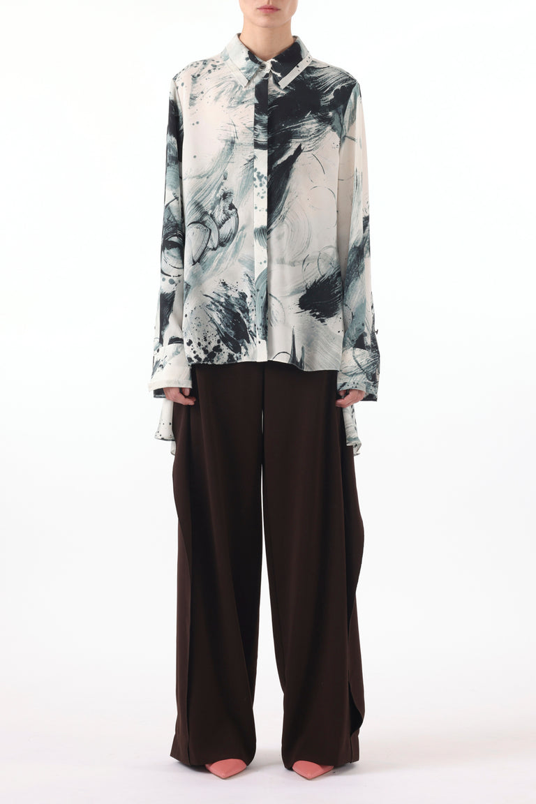 Model wearing a Brushstroke Printed Georgette Button Down Shirt with a loose, flowing silhouette, paired with wide-leg dark brown trousers and pointed-toe shoes, set against a plain white background view 1