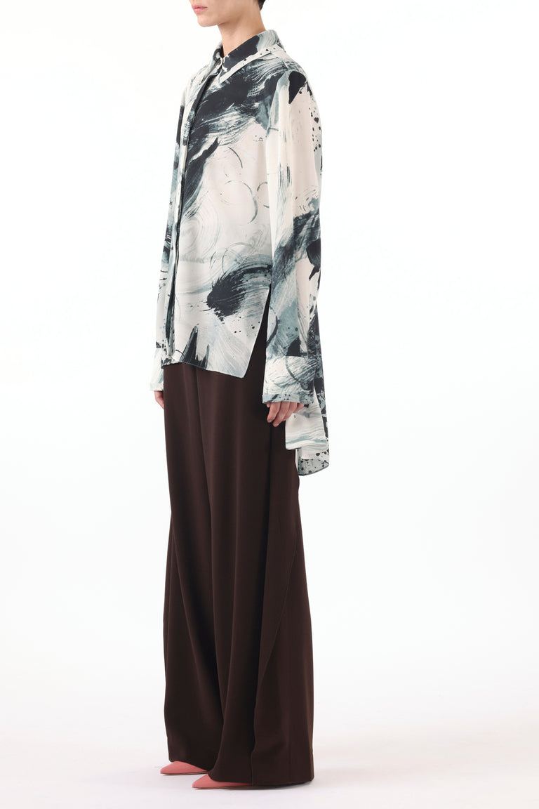 Model wearing a Brushstroke Printed Georgette Button Down Shirt with a loose, flowing silhouette, paired with wide-leg dark brown trousers and pointed-toe shoes, set against a plain white background view 3