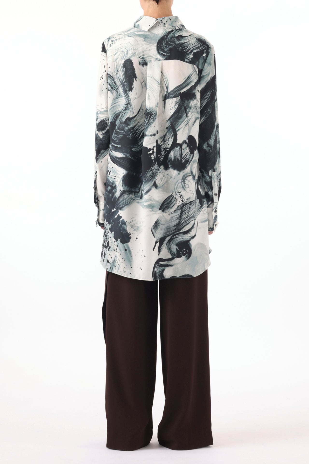 Model wearing a Brushstroke Printed Georgette Button Down Shirt with a loose, flowing silhouette, paired with wide-leg dark brown trousers and pointed-toe shoes, set against a plain white background view 4