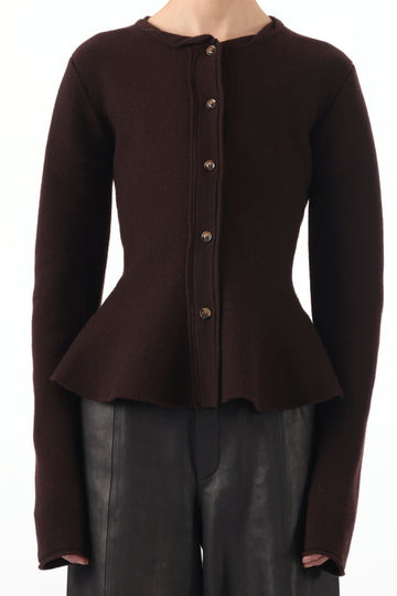 Model wearing a boiled wool cardigan with a peplum design, styled for a cozy, chic look. view 1