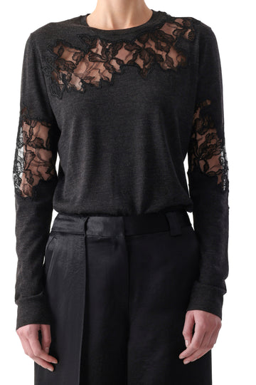 Model wearing a graphite merino crewneck sweater with lace accents at neckline and cuffs. view 1